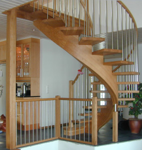 Svängd trappa med ett underliggande vangstycke och rostfrria räckespinnar